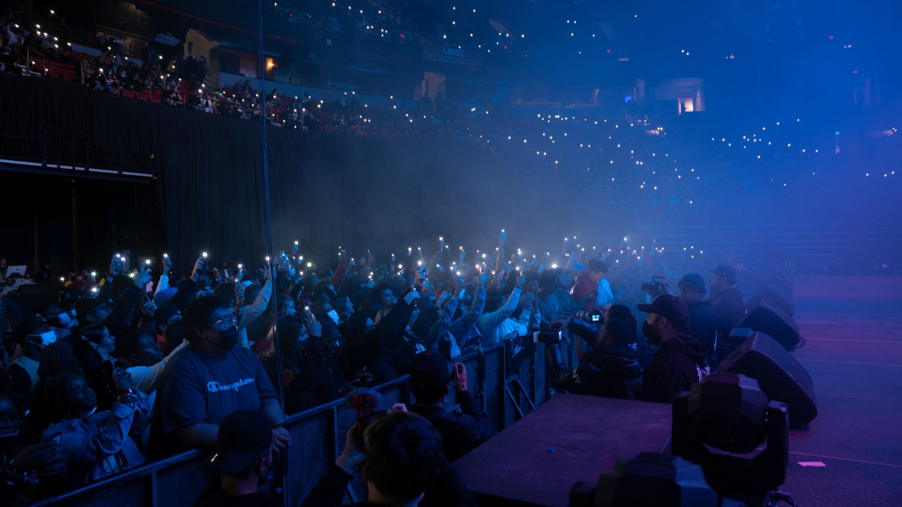 Arena crowd lit by thousands of phone lights