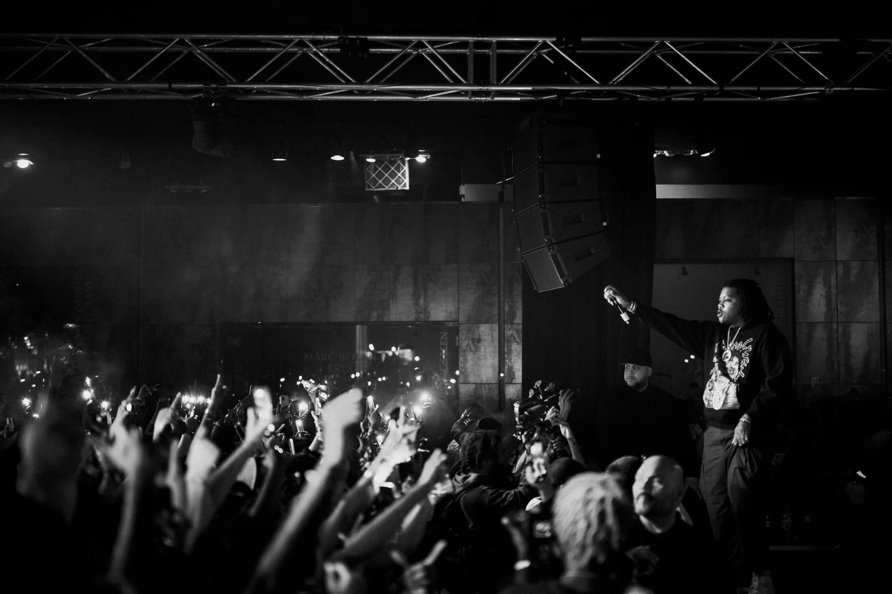 Black and white shot of a performer above a roaring crowd