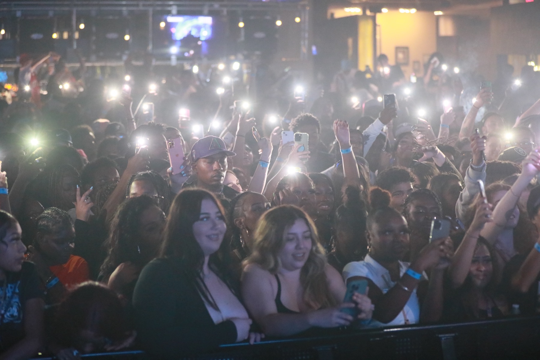 Dense crowd with phones raised toward the stage