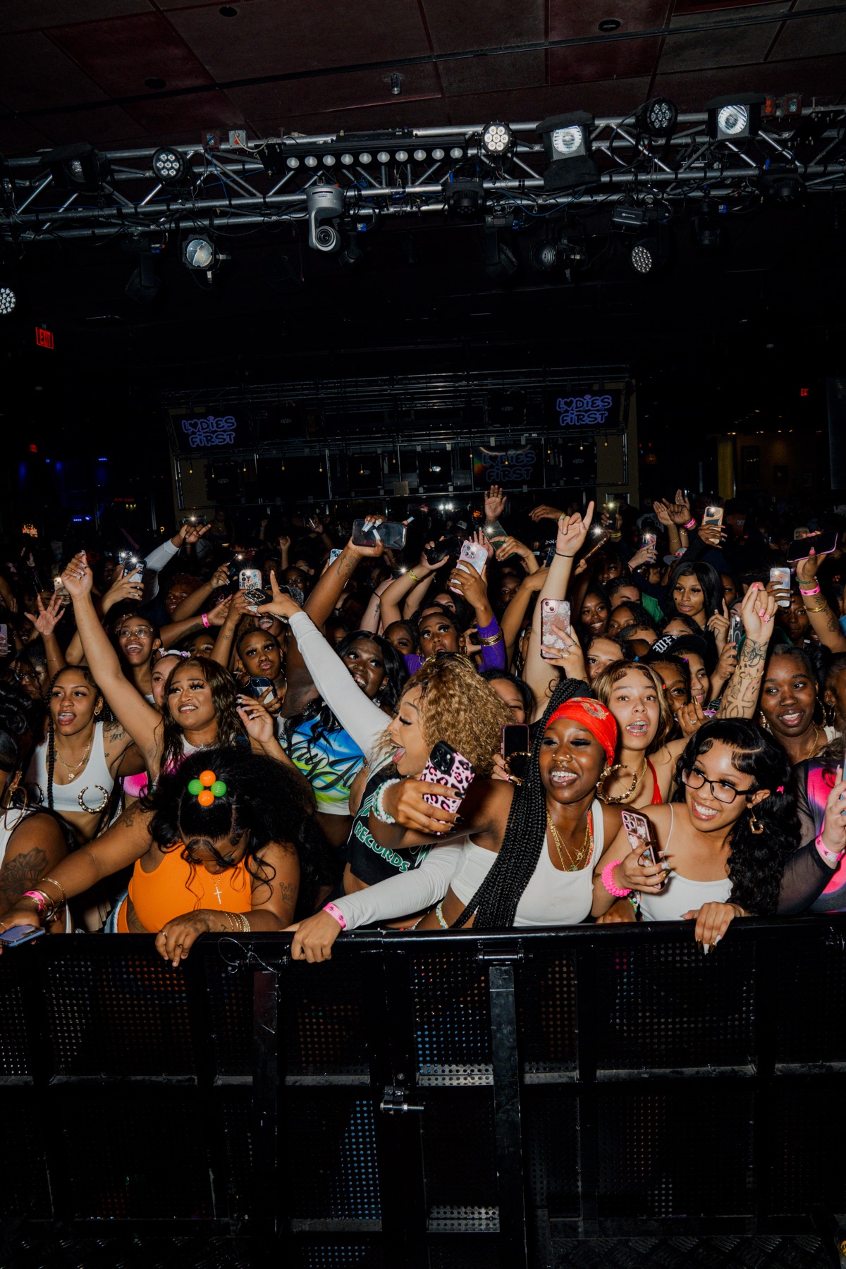 Front-row fans cheering against the barricade