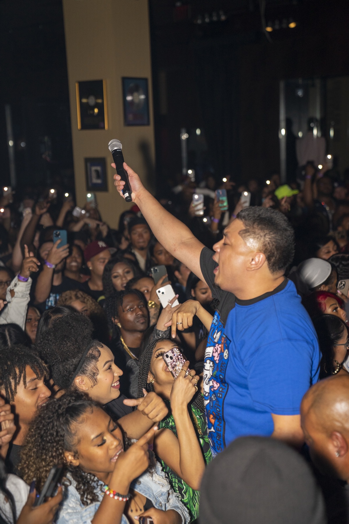 Host holding a microphone high in the middle of the crowd