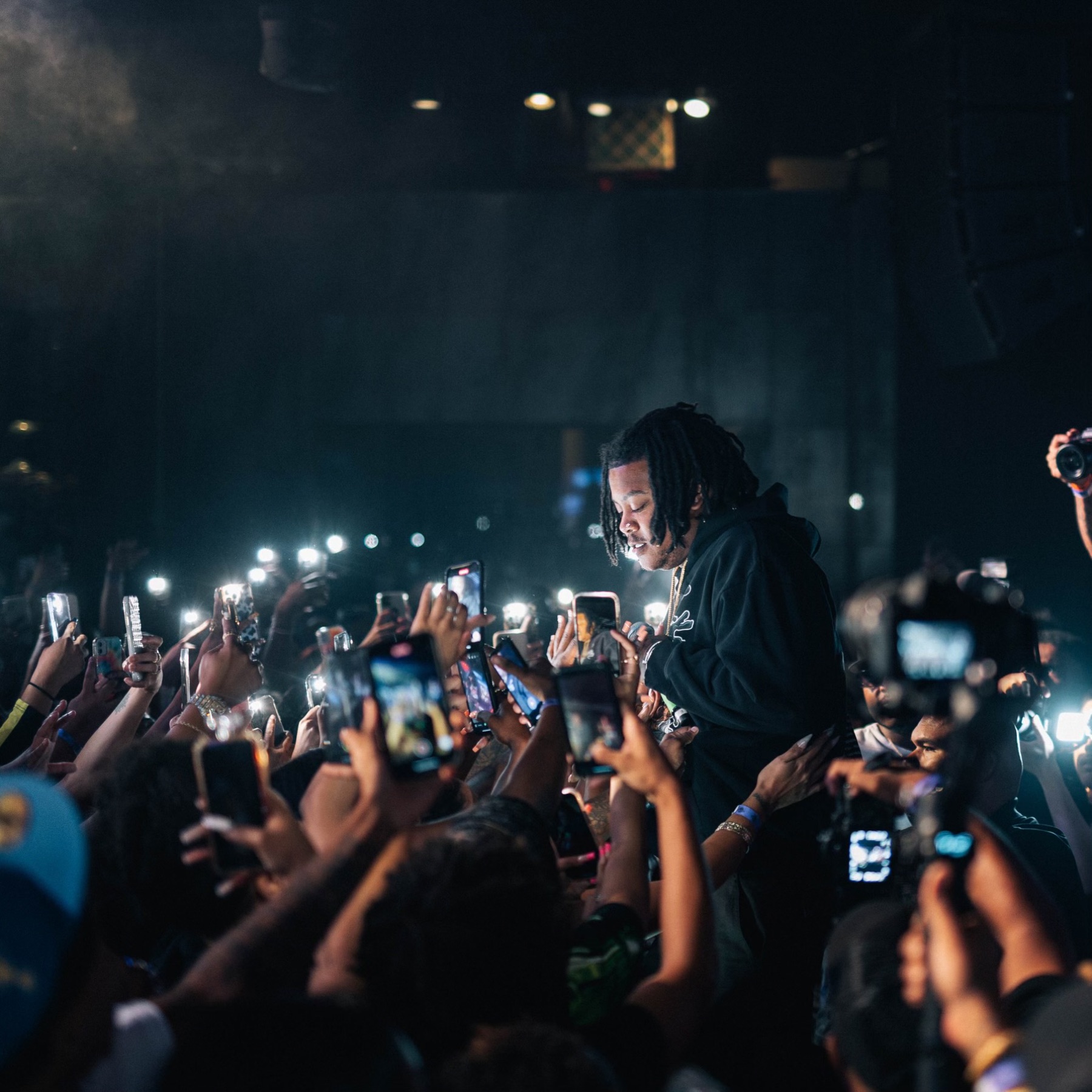 Artist surrounded by a sea of fans filming on their phones