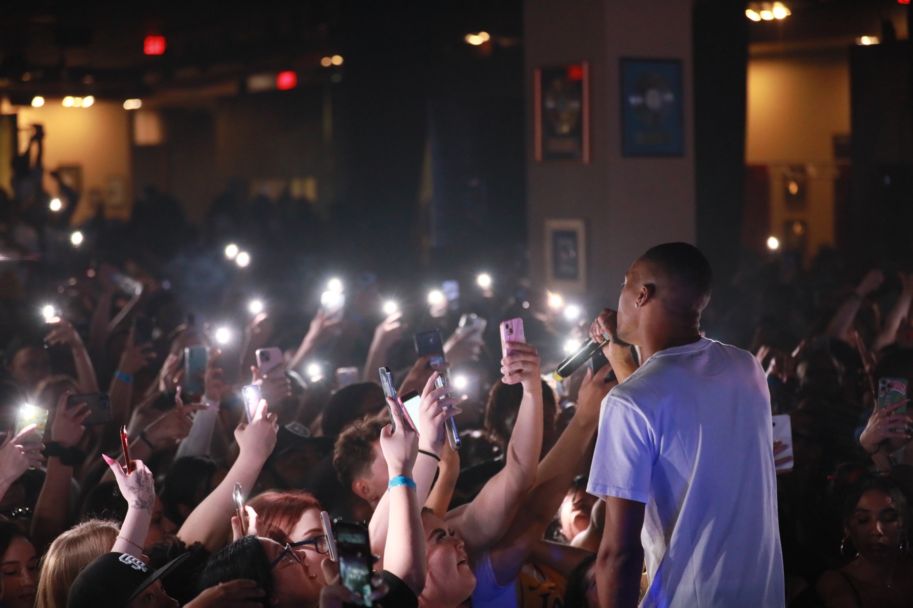 Performer engaging a crowd holding their phones up